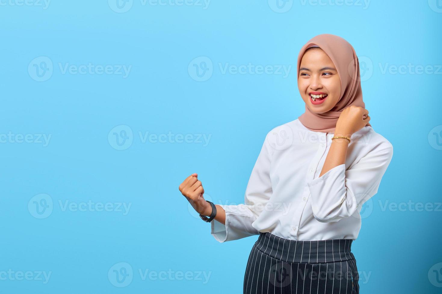 ritratto di giovane donna asiatica eccitata che urla celebrando il successo con le mani alzate foto