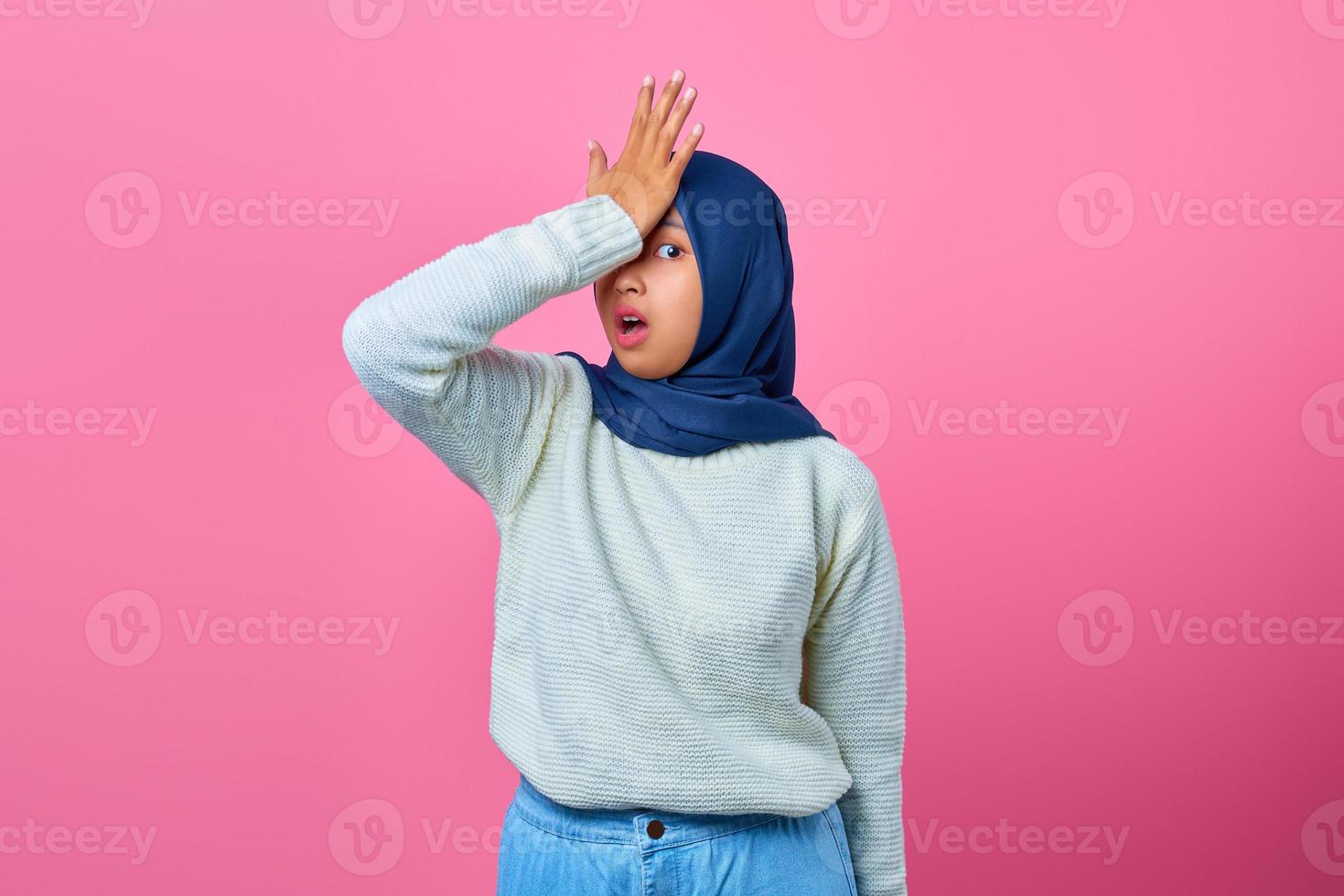 ritratto di giovane donna asiatica scioccata mano sulla testa con espressione delusa foto