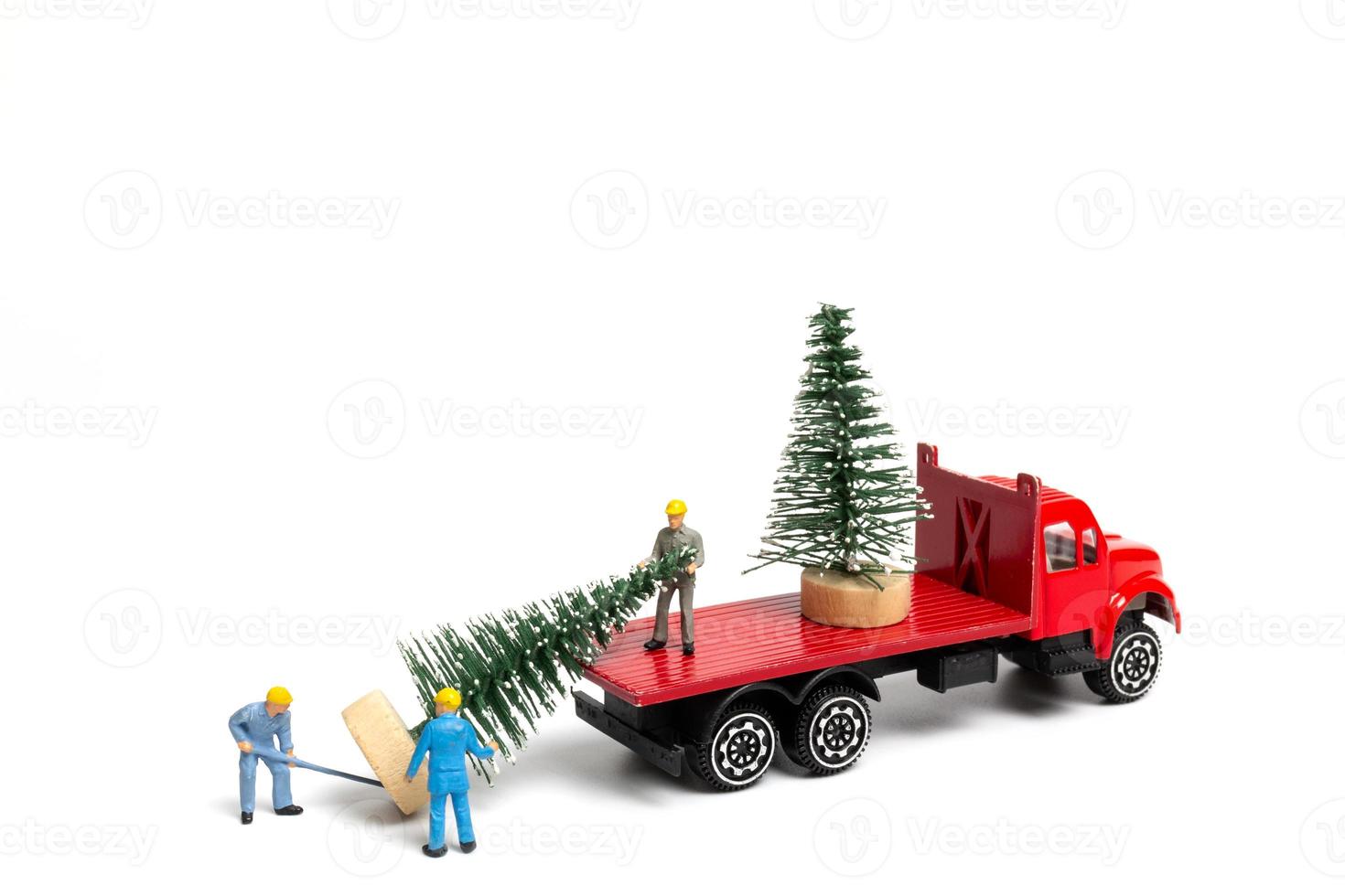 persone in miniatura, lavoratore che prepara l'albero di natale su sfondo bianco foto