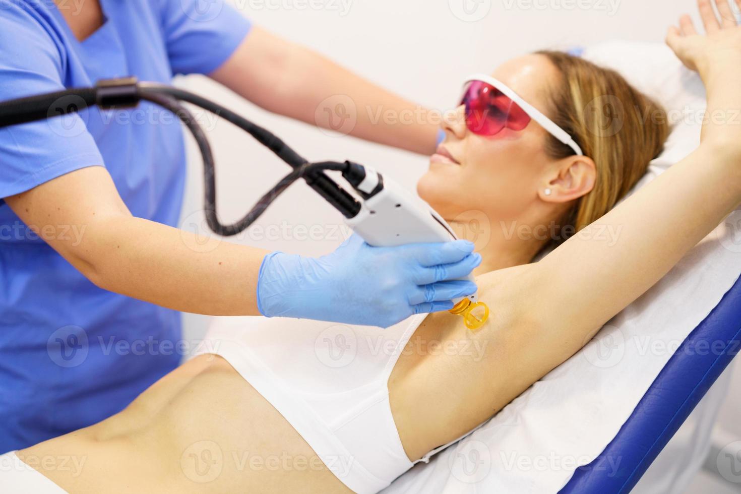 donna che riceve la depilazione laser ascellare in un centro di bellezza. foto