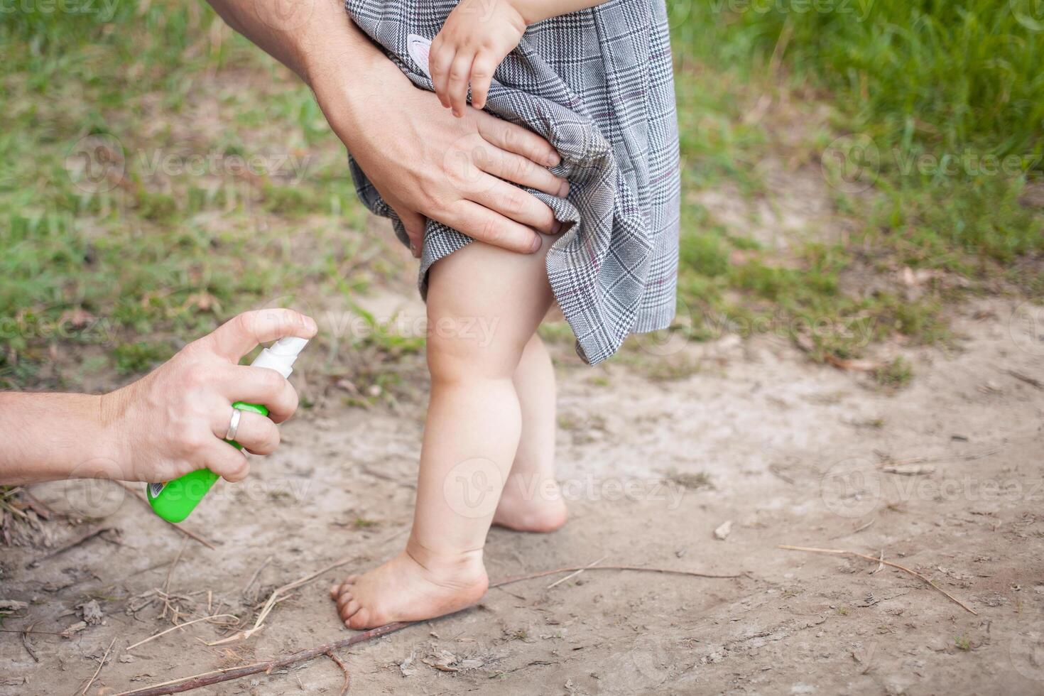 papà ossequi il suo figlia con zanzara spray. il uomo usi spray su il del bambino braccia e gambe. protezione a partire dal zanzare nel il foresta. spray a partire dal zanzare nel natura foto