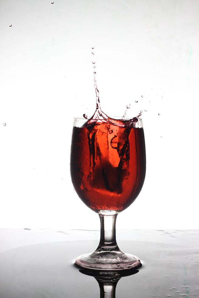 spruzzi cocktail in un' vino bicchiere foto
