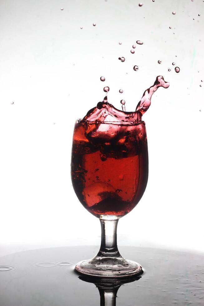 spruzzi cocktail in un' vino bicchiere foto