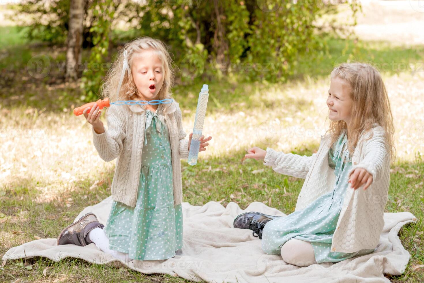 2 sorelle a un' picnic giocando con sapone bolle. estate vacanze 3 bionda ragazze. foto