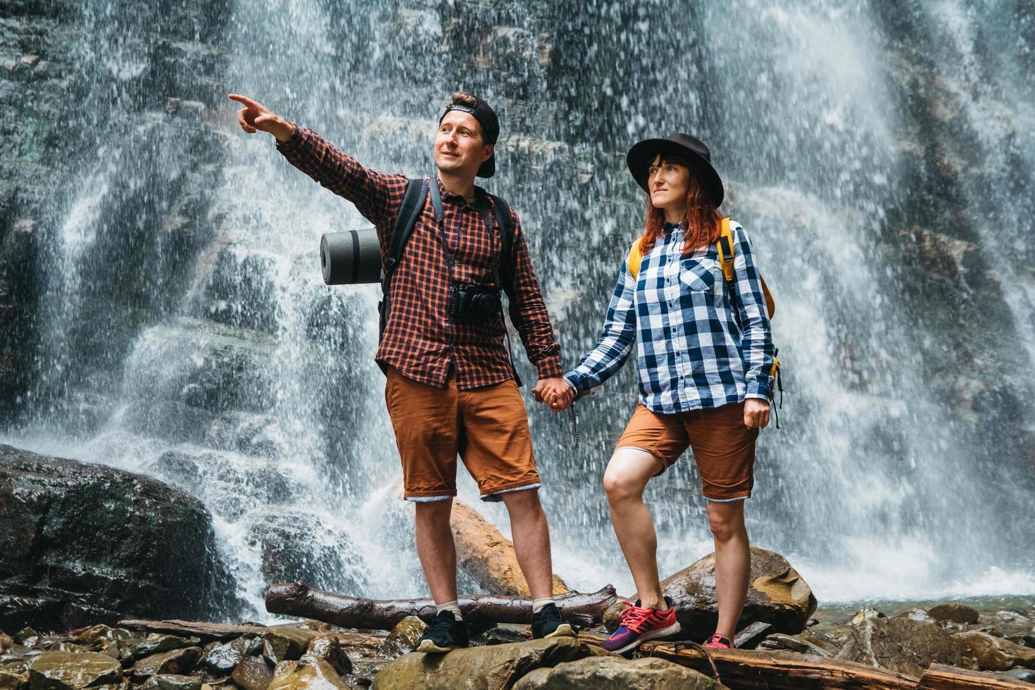 uomo e donna escursionisti trekking un sentiero roccioso sullo sfondo di una cascata e rocce foto