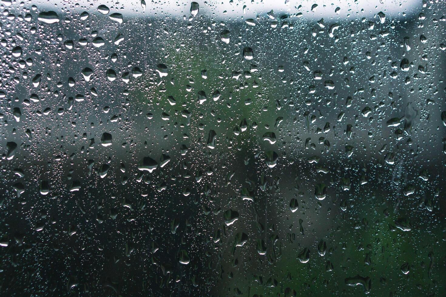piovoso giorni pioggia gocce su il finestra superficie. sfondo e trama di bagnato finestra con piovoso gocce foto