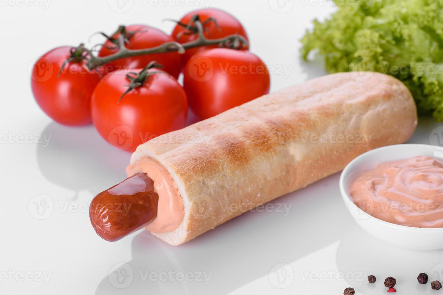 Deliziosa grigliata di hot dog francese fresca con panino, salsiccia da latte e salsa foto