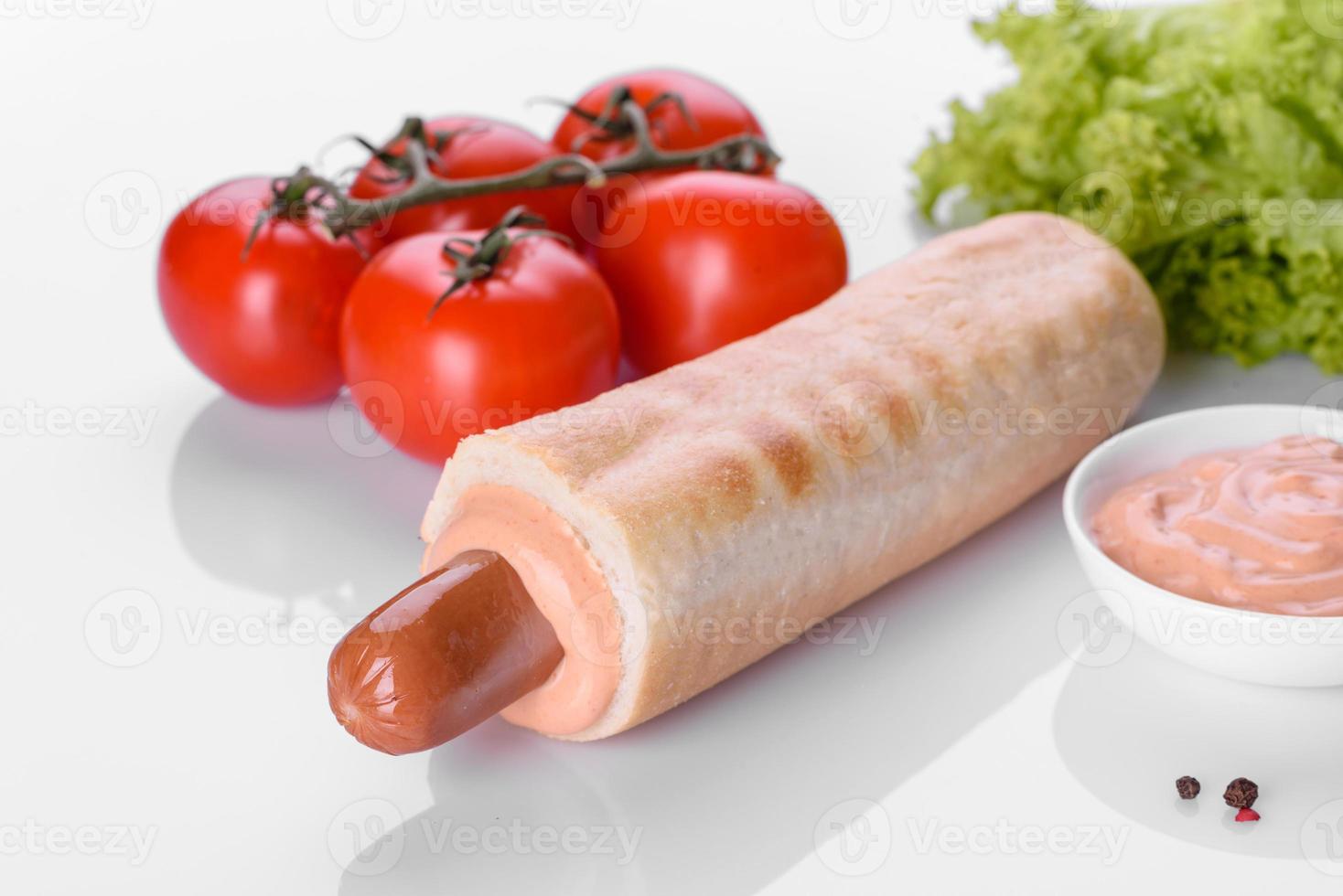 Deliziosa grigliata di hot dog francese fresca con panino, salsiccia da latte e salsa foto