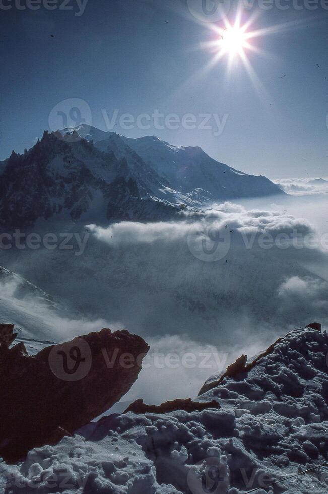 un' persona in piedi su un' montagna superiore con un' neve coperto paesaggio foto