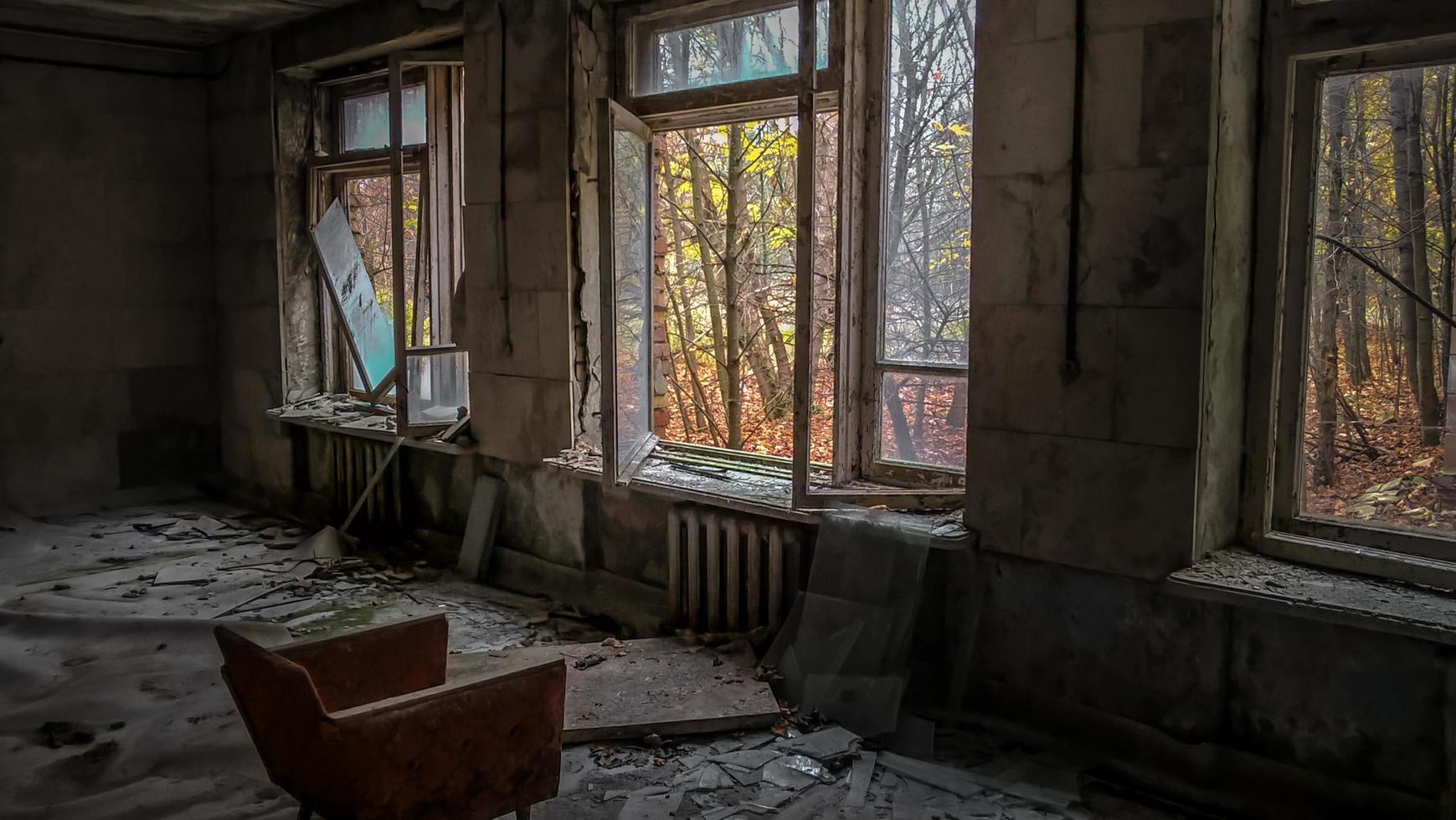 pripyat, ucraina, 2021 - finestre di fronte alla sedia in una casa abbandonata a Chernobyl foto