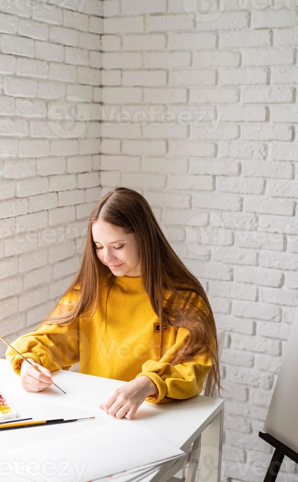 artista femminile che dipinge un quadro con l'acquerello in studio foto