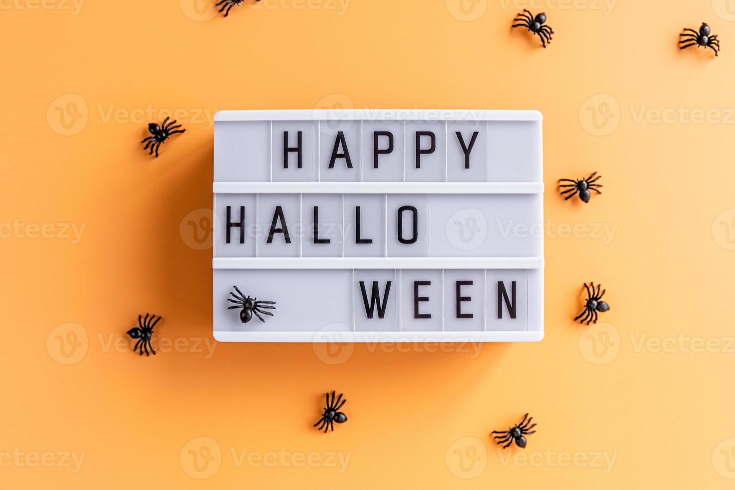 Happy halloween cinema lightbox con vista dall'alto di ragni su sfondo arancione foto