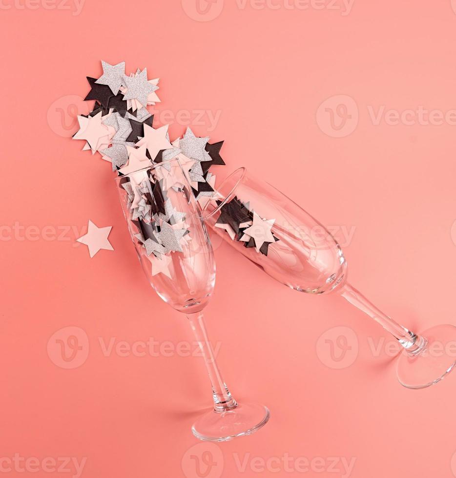 bicchieri di champagne su sfondo rosa con coriandoli foto