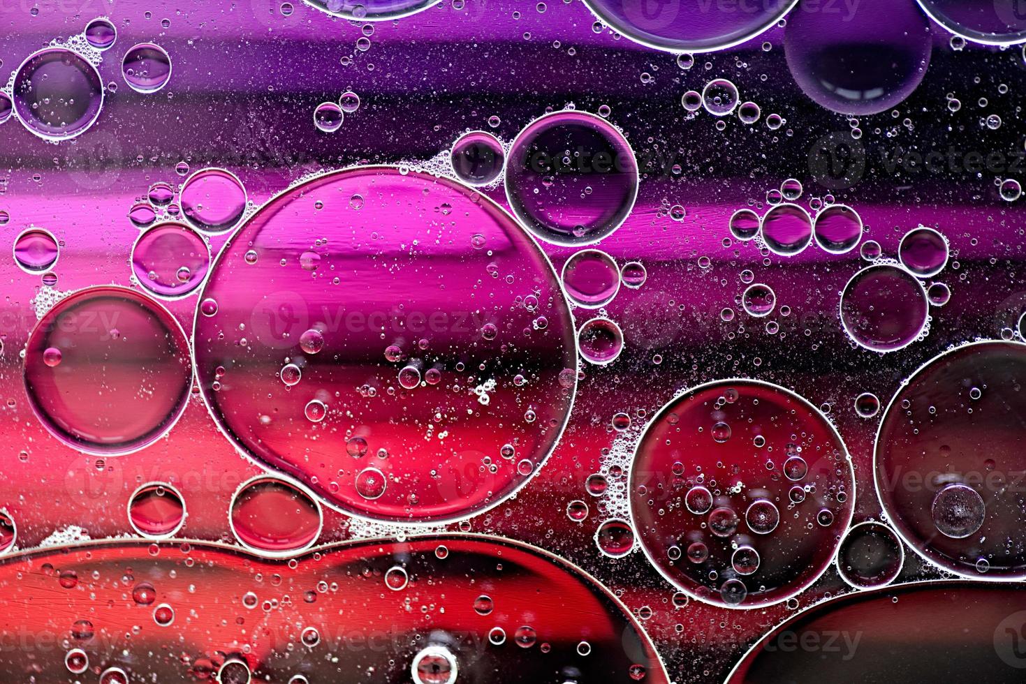 motivo astratto rosa e viola realizzato con bolle d'olio sull'acqua che si alzano in movimento foto