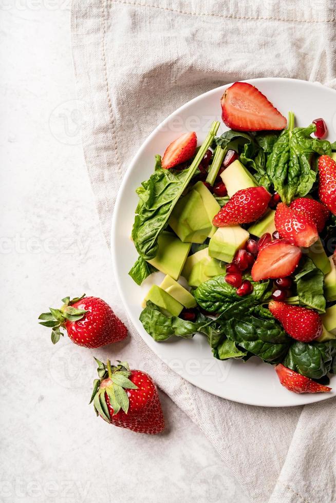 insalata con spinaci, avocado e fragole su sfondo bianco vista dall'alto flat lay foto