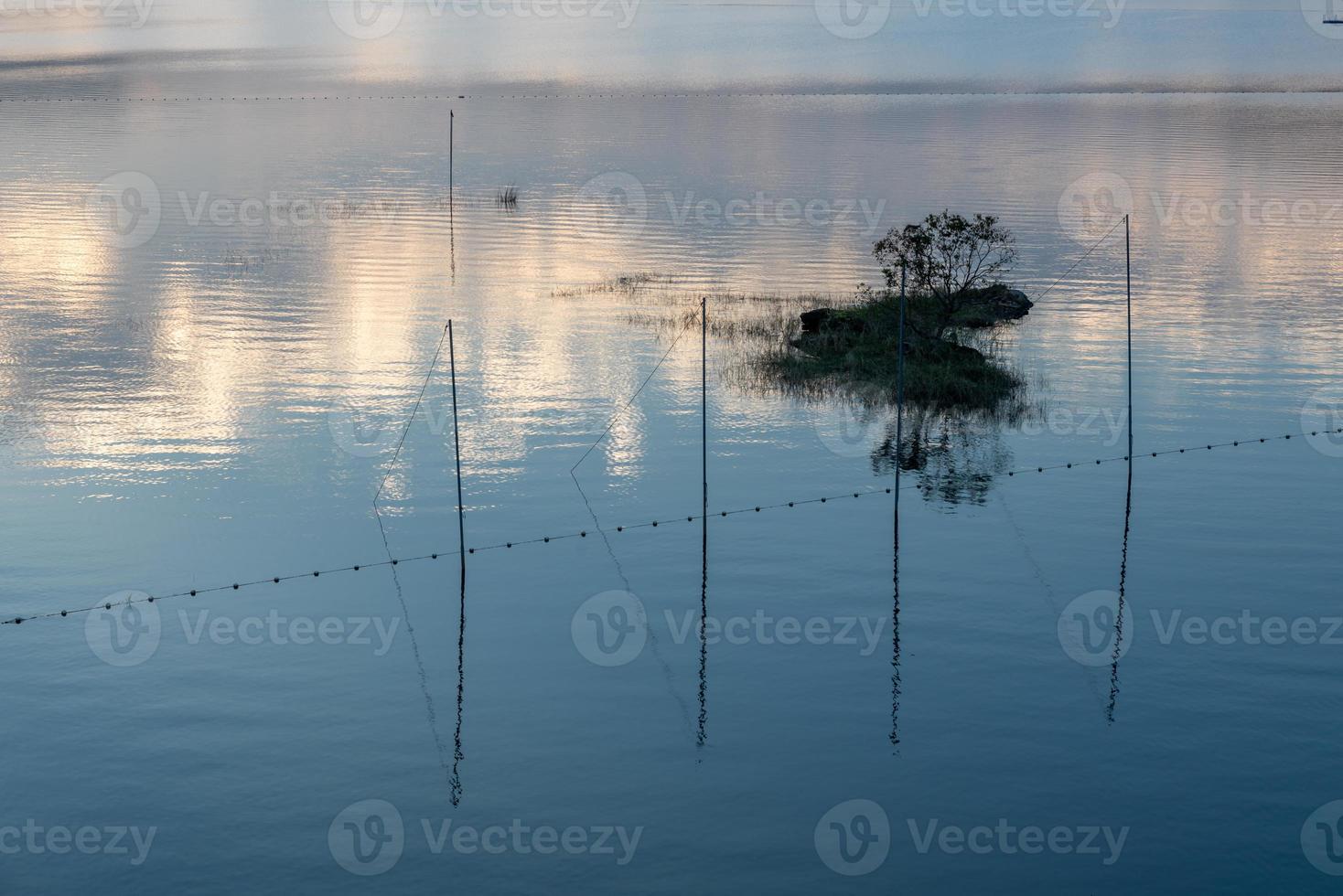 il lago della sera rifletteva il bagliore del tramonto e le montagne foto