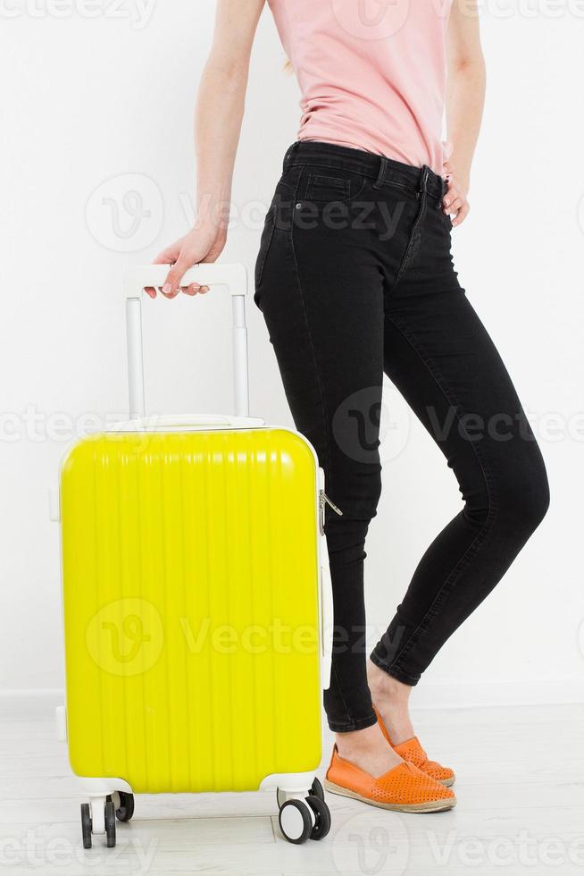 ragazza con la valigia gialla isolata su priorità bassa bianca. Vacanze estive. valigia o borsa da viaggio. modello. copia spazio. modello. vuoto. foto