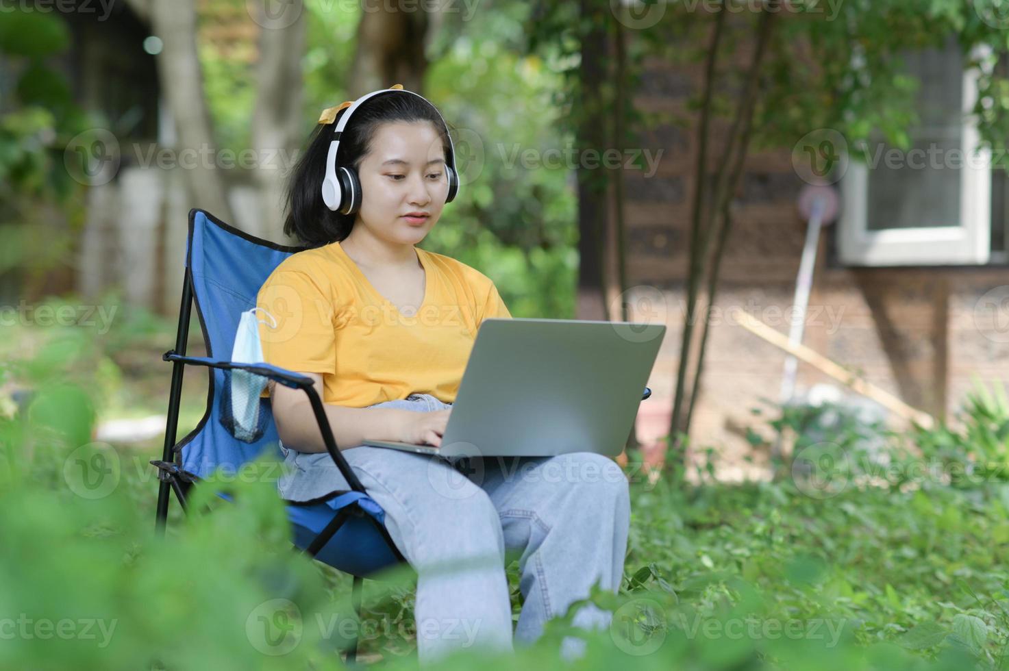 giovane donna che lavora su un laptop in giardino a casa, lavora da casa. foto