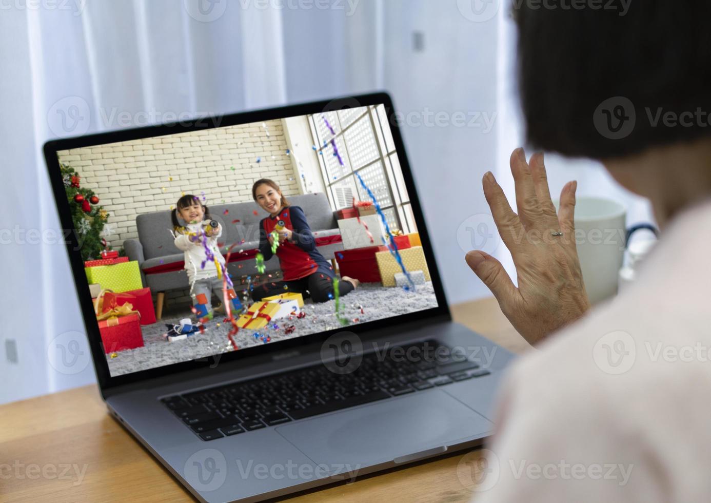 donna anziana festeggia il natale con la famiglia tramite videochiamata foto