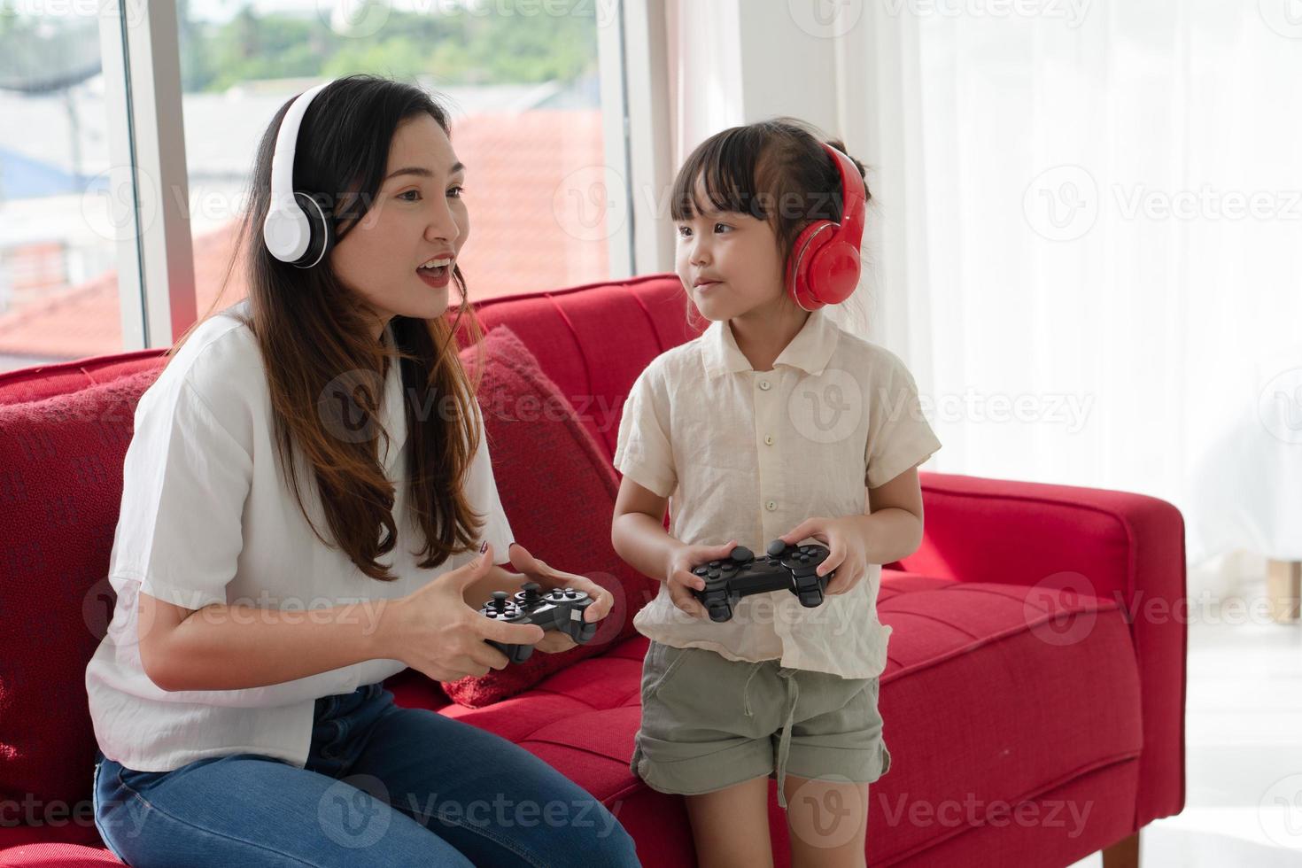 giovane ragazzo asiatico e mamma che giocano a giochi di realtà virtuale a casa. concetto di famiglia insieme foto