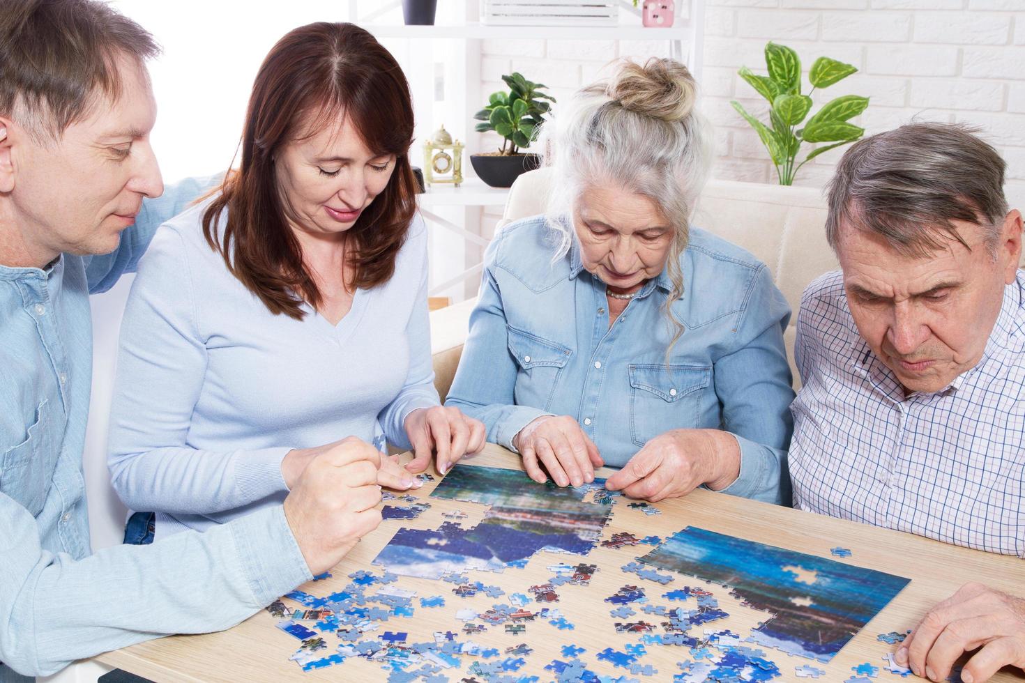 coppia senior che risolve puzzle insieme alla famiglia a casa. foto