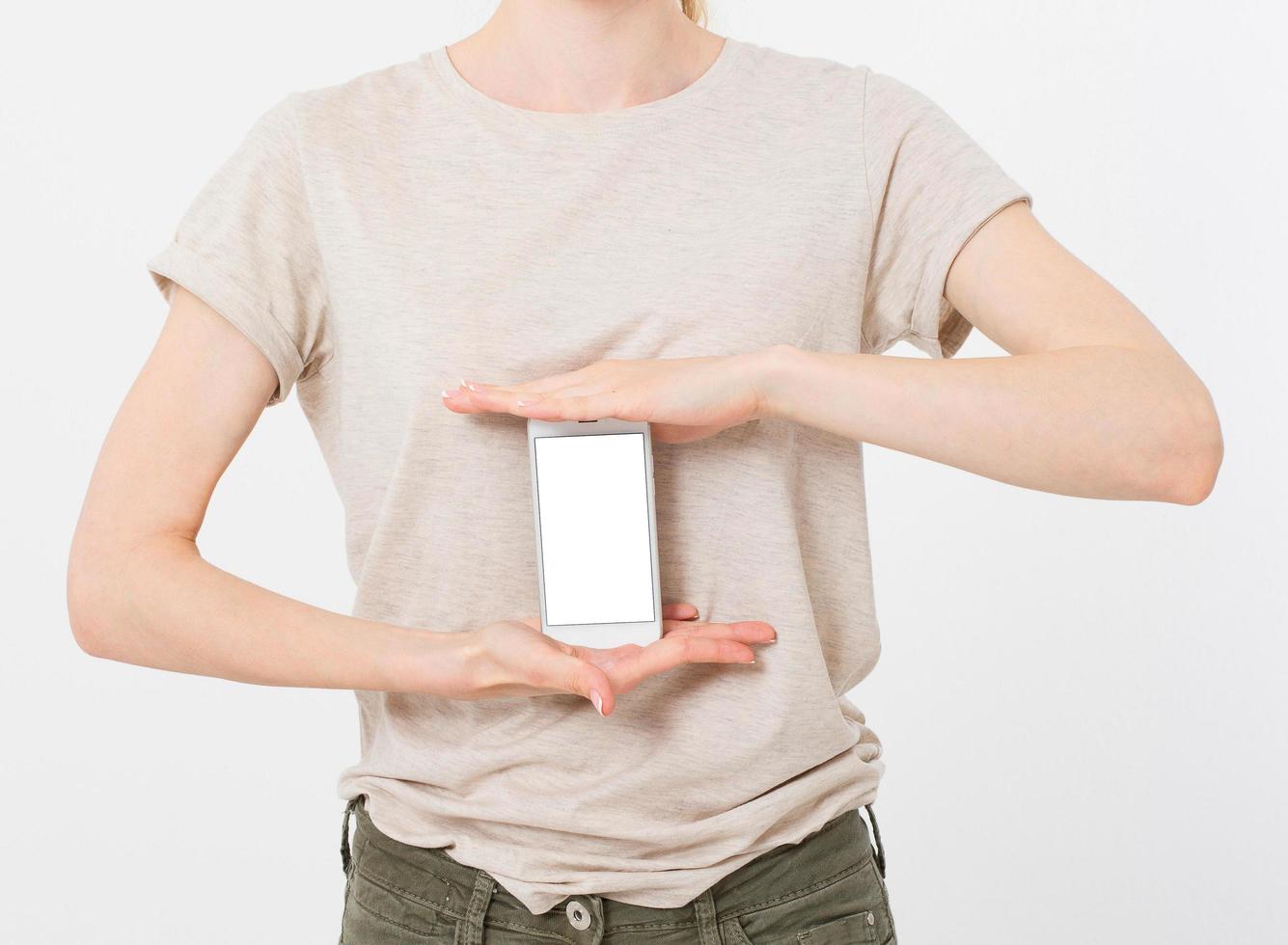 la donna mostra il display vuoto del telefono cellulare, la mano punta al dispositivo, cellulare schermo vuoto foto