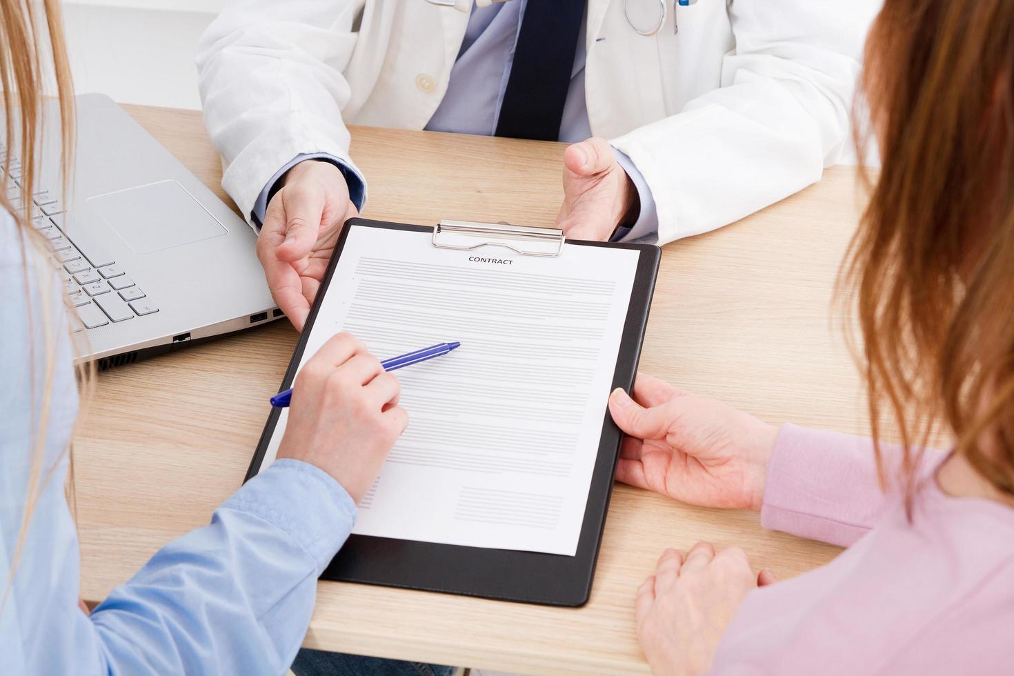 medico con pazienti in studio medico firmano un contratto. concetto di assistenza sanitaria. assicurazione sanitaria. foto