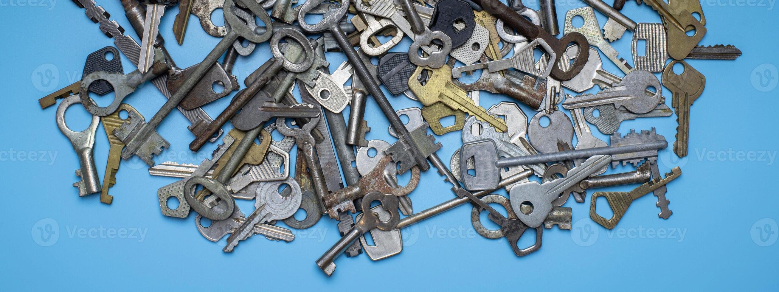 chiavi impostate su sfondo blu. chiavi della serratura e cassaforte per la sicurezza della proprietà e la protezione della casa. diversi tipi di chiavi antiche e nuove. foto