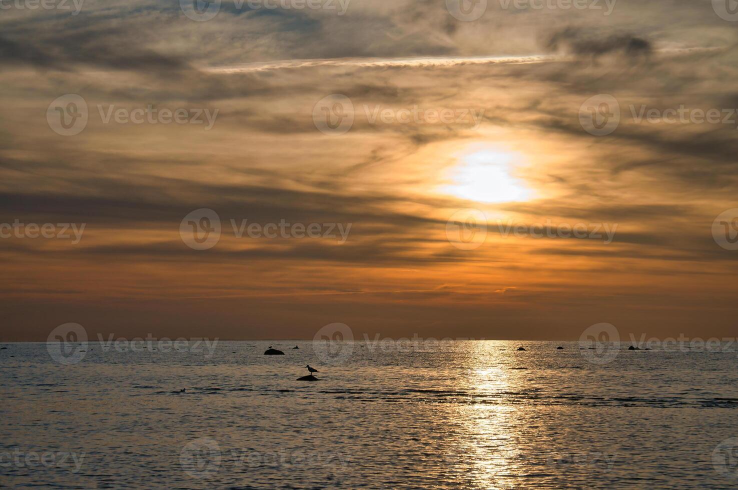 tramonto, illuminato mare. sabbioso spiaggia nel il primo piano. leggero onde. baltico mare foto