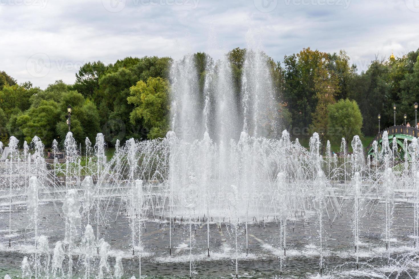 gli spruzzi d'acqua della fontana iniettano da terra mostrando nel parco pubblico. foto