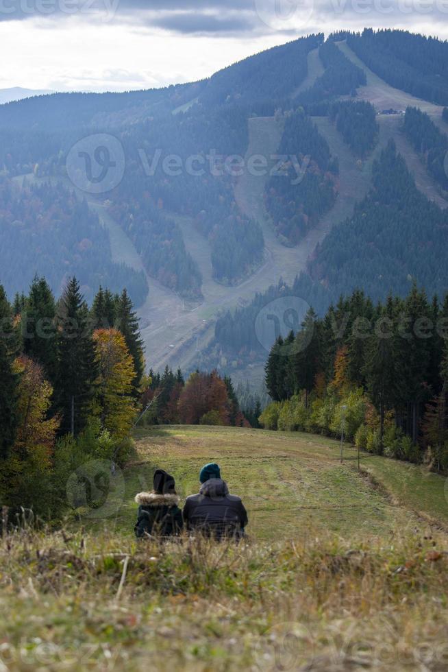 coppia di innamorati seduti sul fianco della montagna foto