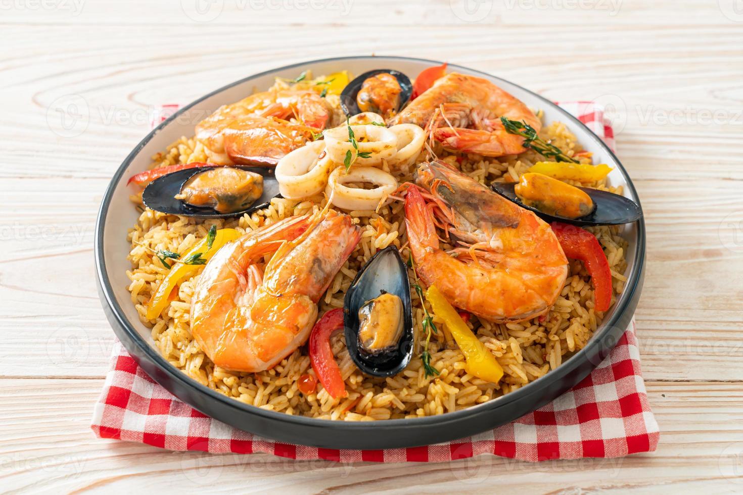 paella di mare con gamberi, vongole, cozze su riso allo zafferano foto