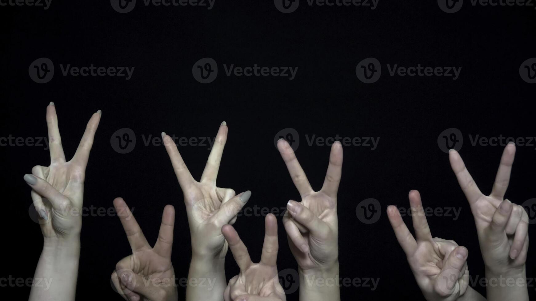 folla mani con cartello di vittoria. avvicinamento di molti mani con pugni sollevato su poi cambiato per cartello di vittoria. metafora di guerra e pace foto