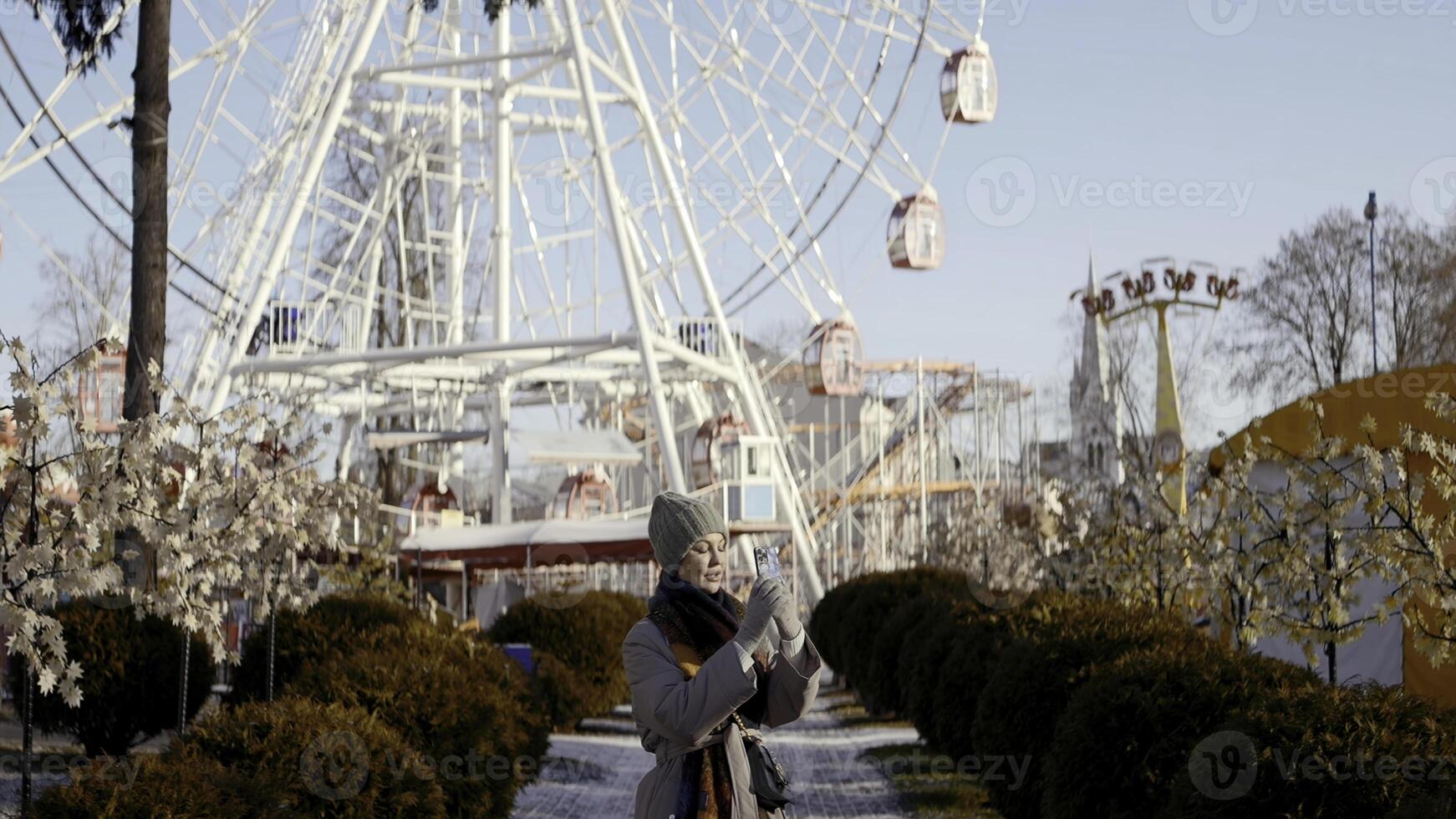 primavera divertimento parco . azione. un' enorme ricreazione parco dove un' lotto di persone camminare e un' enorme bianca Ferris ruota nel il sfondo. foto