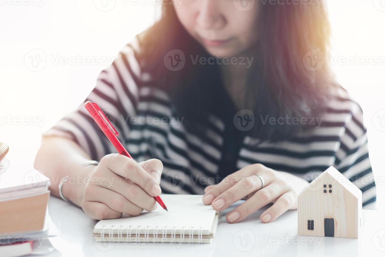 donna scrittura su il carta e Lavorando a casa foto