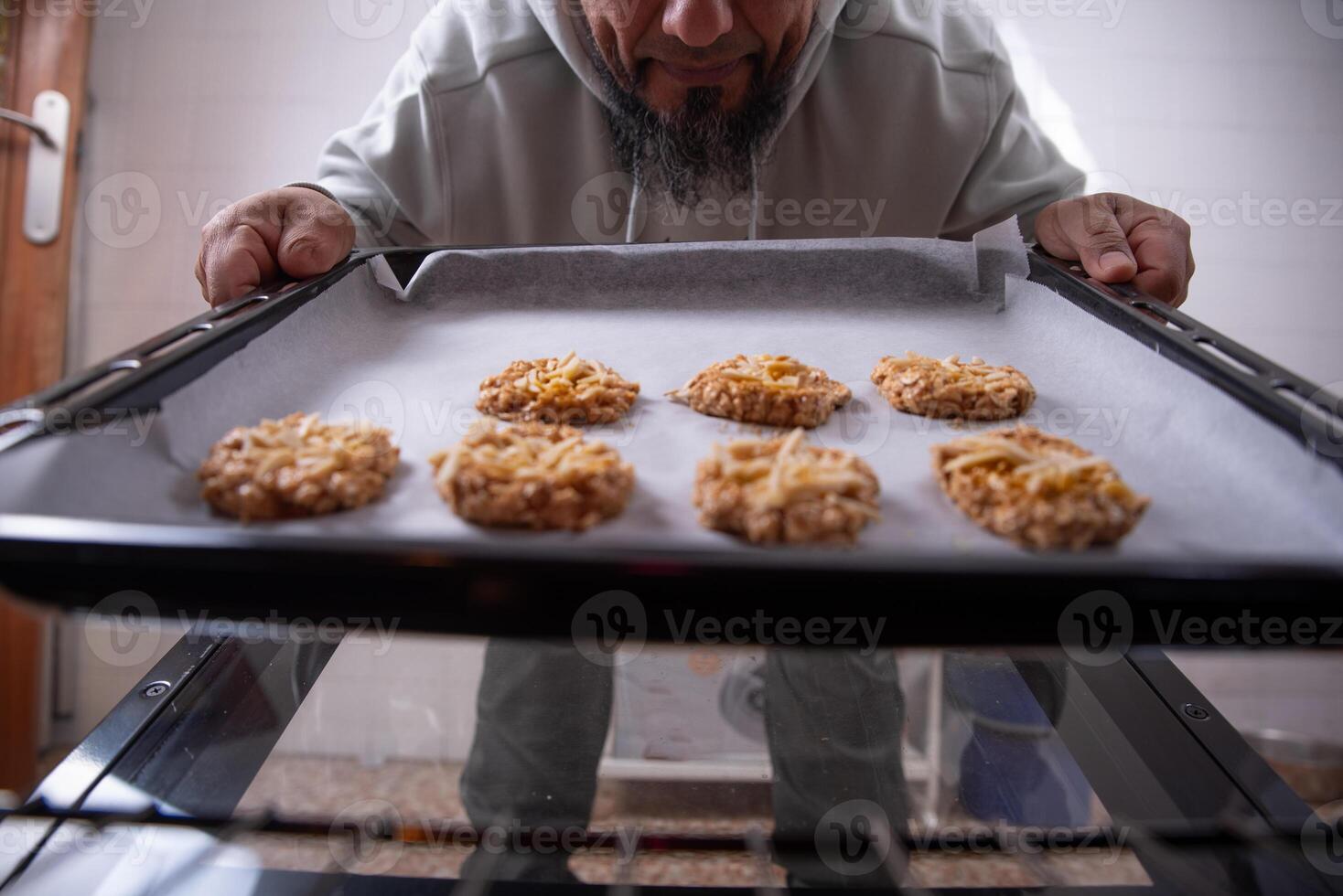 uomo con biscotti pronto per mettere nel il forno. foto