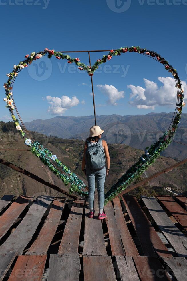 turista in piedi su un' punto di vista Il prossimo per un' a forma di cuore decorazione. foto