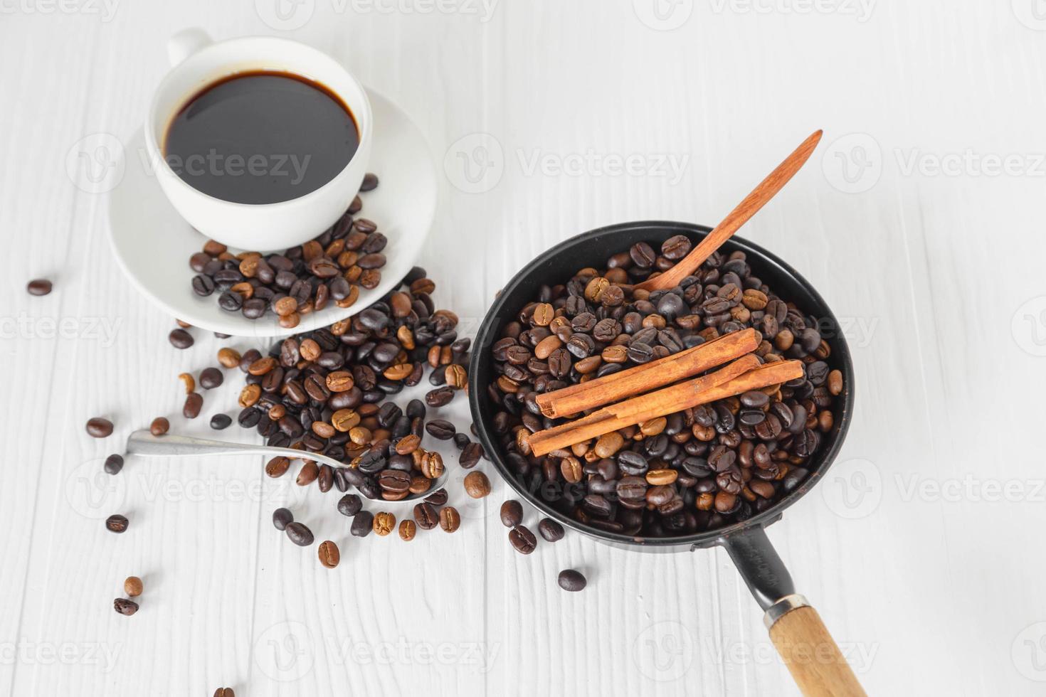 tazza di caffè e chicco di caffè sul tavolo di legno bianco foto