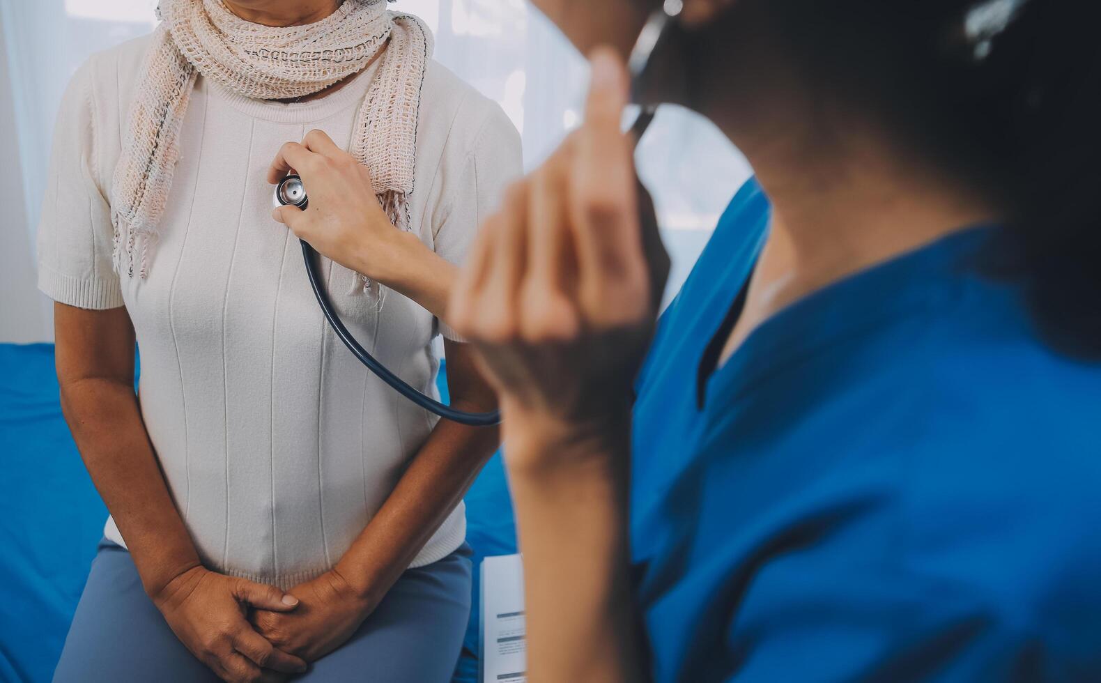 vicino su di femmina medico utilizzando stetoscopio mettendo battere cuore diagnosticare con paziente nel visita medica camera a un' Ospedale, verifica corpo, medico e Salute cura concetto. foto