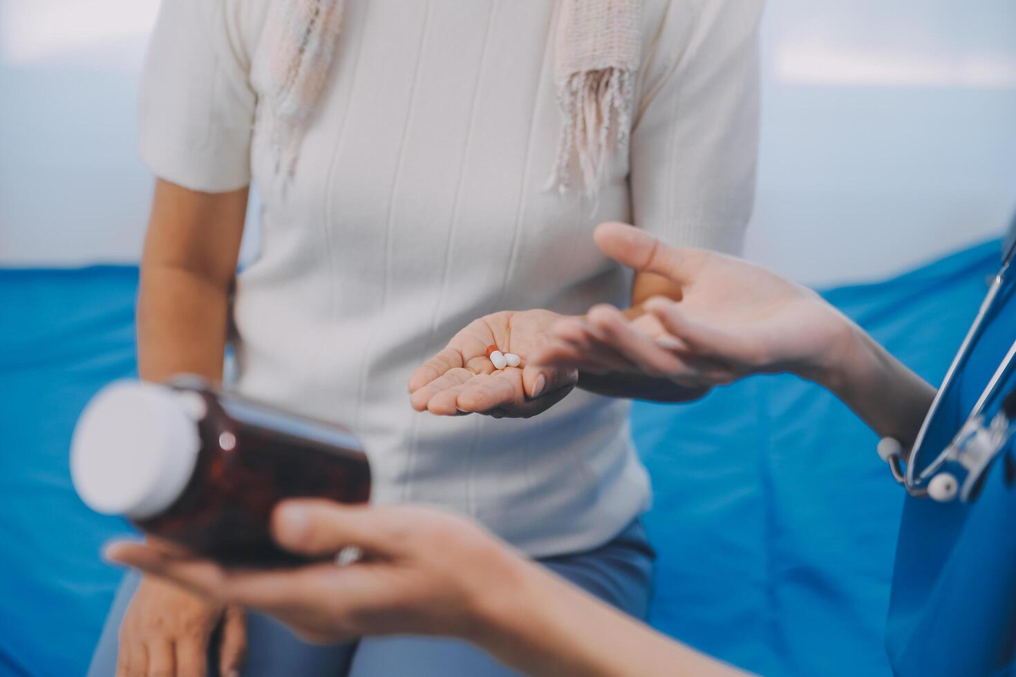 asiatico donna infermiera Tenere un' medicina bottiglia e telling informazione per asiatico anziano donna prima amministrazione farmaco. badante visitare a casa. casa Salute cura e assistenza infermieristica casa concetto. foto