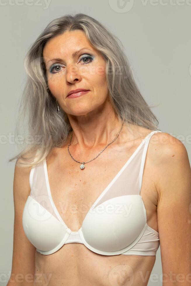 ritratto di un' bellissimo dimagrante donna di cinquanta anni vecchio nel un' reggiseno. foto