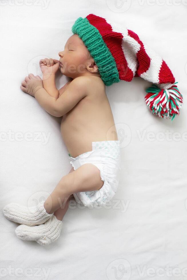neonato bambino indossare un' Natale a maglia gnomo cappello. foto