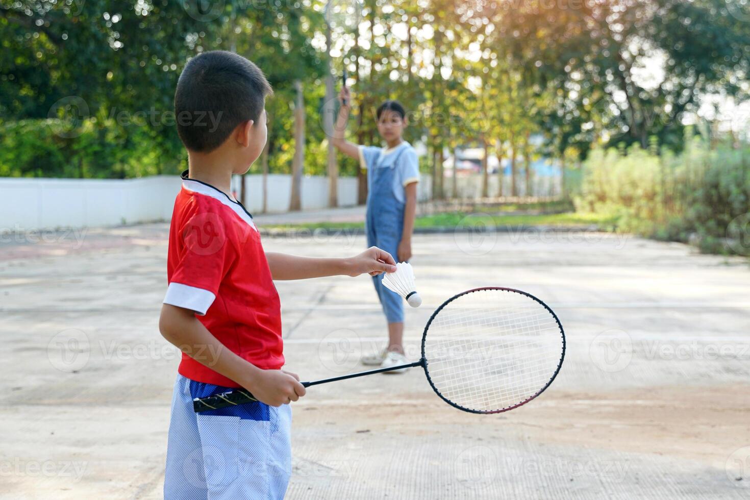 asiatico ragazza e ragazzo giocare badminton all'aperto a il parco insieme su vacanza. morbido e selettivo messa a fuoco. foto