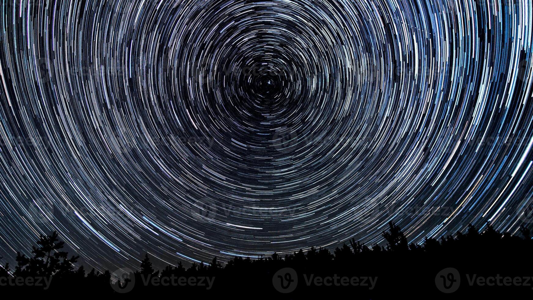 stella sentieri nel il notte cielo. stelle mossa in giro un' polare stella. sagome di alberi foto