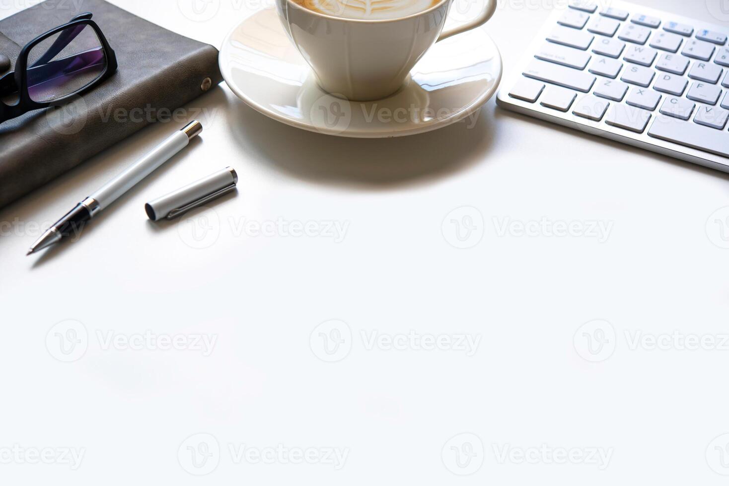 copia spazio, Lavorando scrivania con portatile, cellulare telefono, taccuino matita e caffè su bianca sfondo foto