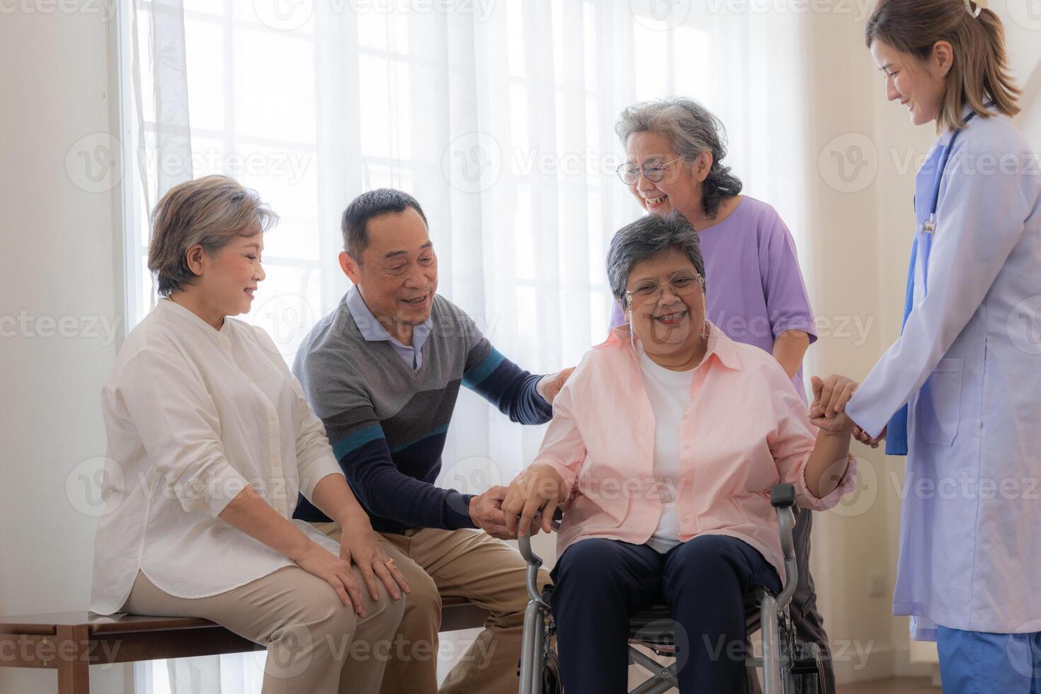 asiatico giovane infermiera supporto coppia anziano più vecchio donna nel un' sedia a rotelle. anziano maturo e un' gruppo di anziano amici vivente nel il Ospedale. socializzazione di pensionato le persone. foto