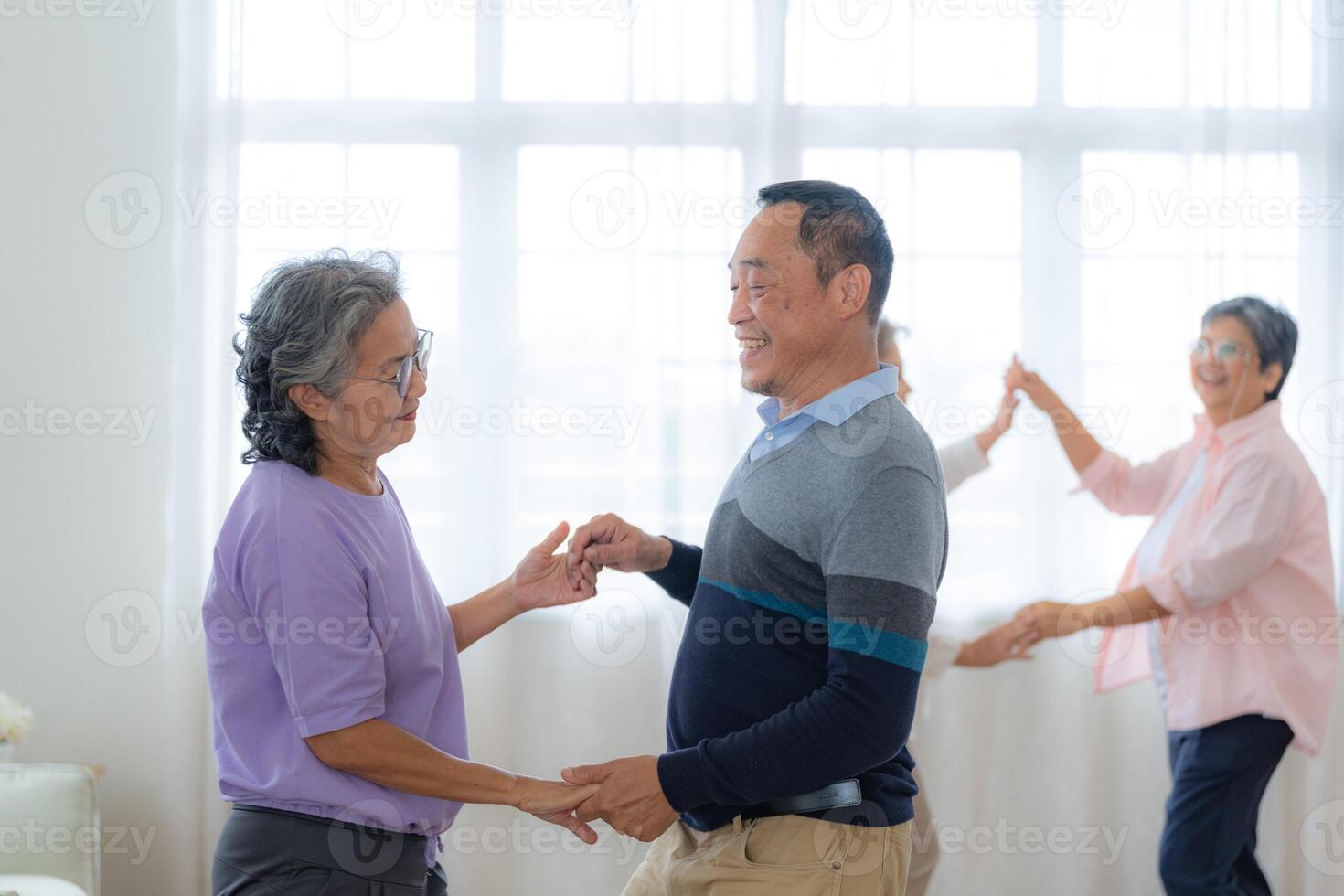 asiatico più vecchio maschio e femmine persone danza con loro partner su un' danza pavimento nel vivente spazio. contento più vecchio coppia l'esecuzione ottenere esercizio. gioioso spensierato pensionato anziano amici godendo rilassamento foto