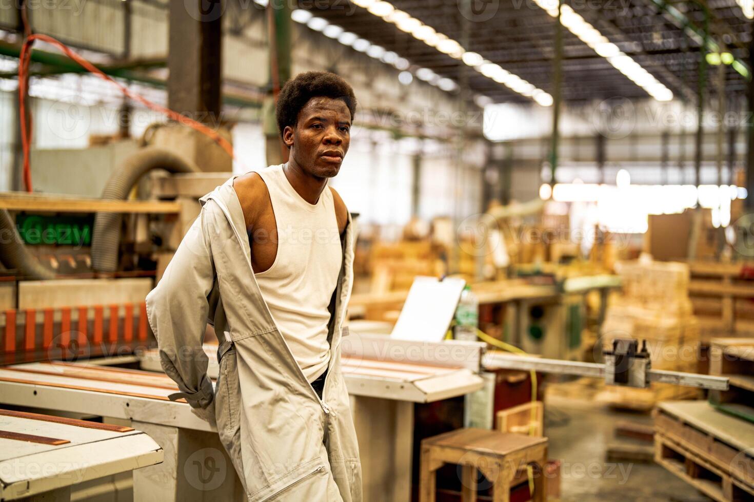 africano uomo lavoratori ingegneria in piedi con fiducia con Lavorando suite vestito e mano guanto nel davanti macchina. concetto di inteligente industria lavoratore operativo. legna fabbrica produrre legna palato. foto