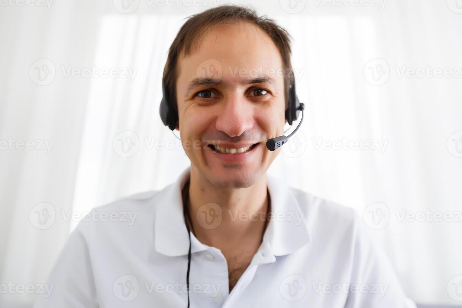 contento uomo d'affari nel il ufficio su il Telefono, cuffia, Skype. guardare telecamera foto