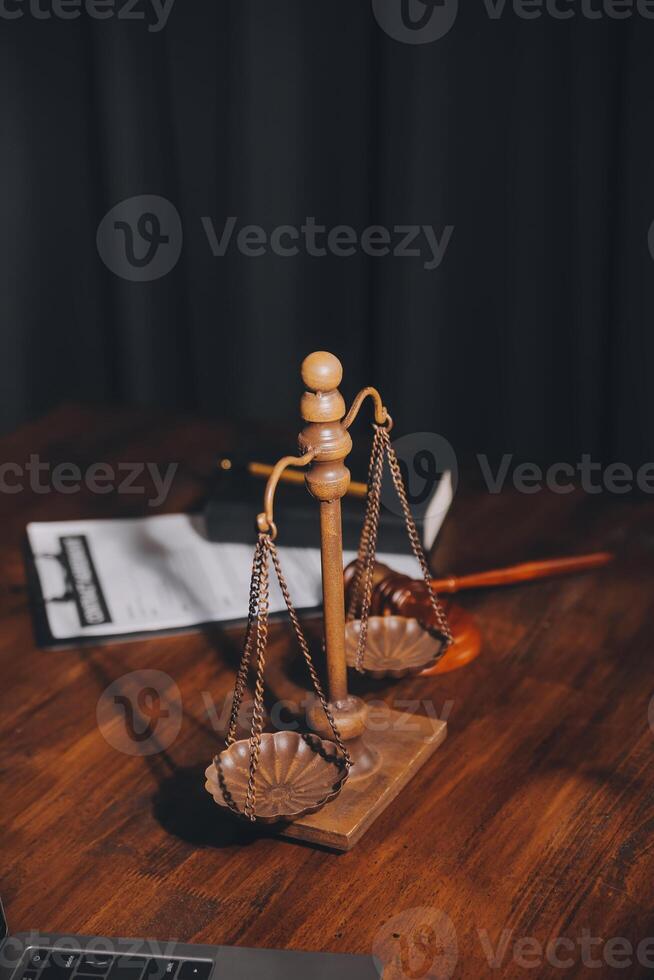 Immagine di giudici martello, bilancia signora di giustizia, legge prenotare, il computer portatile computer e contrarre documenti con penna concetto di legge e giustizia. foto